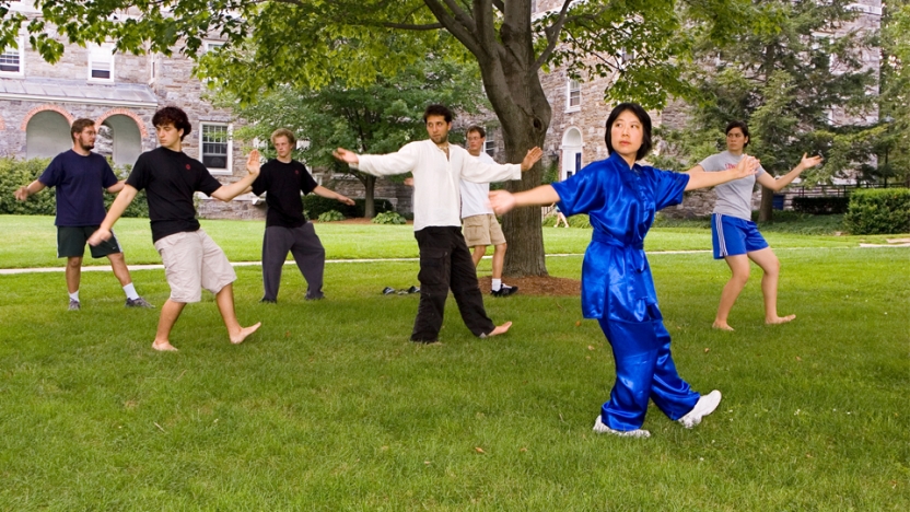 Chinese school students learning dance on campus green.