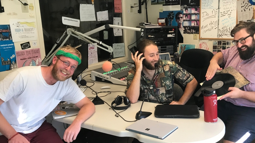 Three male German School students work in the radio studio.