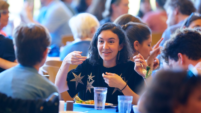 Female School of Hebrew student talks to her friends while eating lunch.