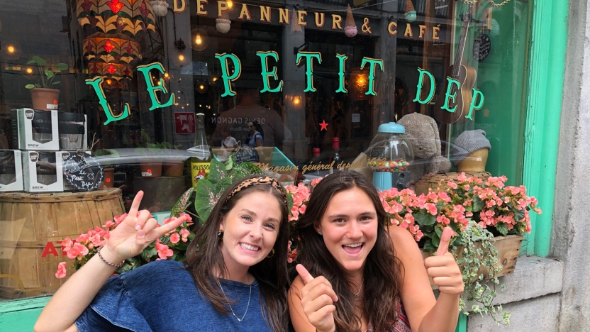 Two female French language school students sitting outside a cafe in Montreal.
