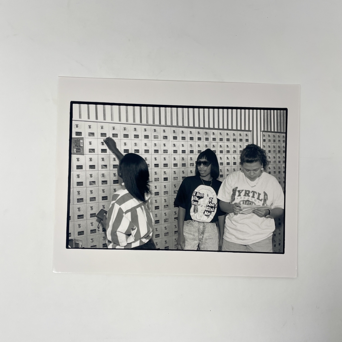 a group of three students standing near mailboxes in McCullough student center