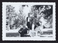 Bread Loaf Writers' conference attendees standing and seated in Adirondack chairs outside 