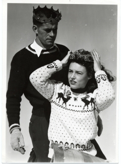 winter carnival king and queen posing with crowns in knit sweaters