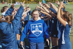 Jean Seeler-Gifford runs through a tunnel of Women's Field Hockey Team players