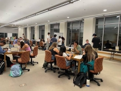 Image of students at multiple tables working and studying