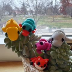 image of five 3d printed animals, yellow shark, green platypus, grey manatee, pink lizard, orange fox