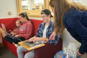 Librarian talking with student using laptop