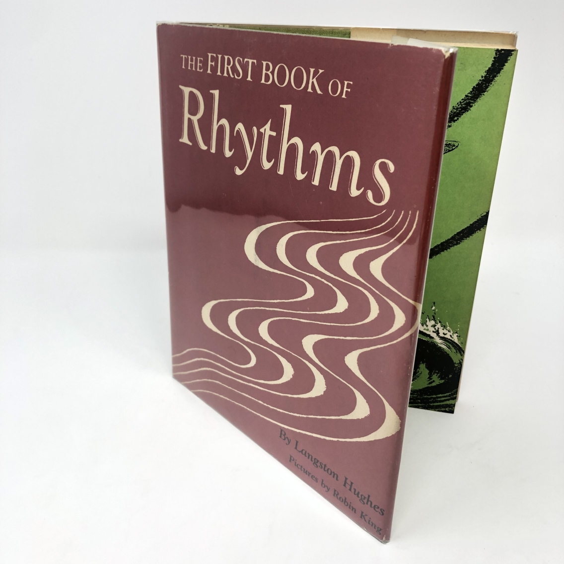 Photograph of the cover of The First Book of Rhythms by Langston Hughes. The cover is maroon.