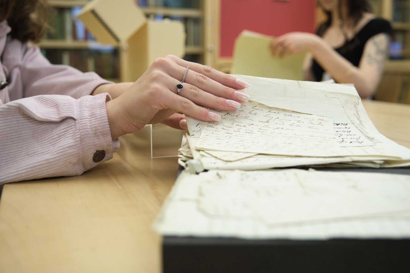 Student leafs through papers in Special Collections reading room