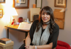 Photograph of Natasha Trethewey, seated at a desk with hands clasped. 