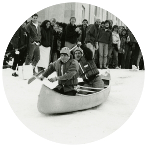Students canoeing down a hill covered in snow