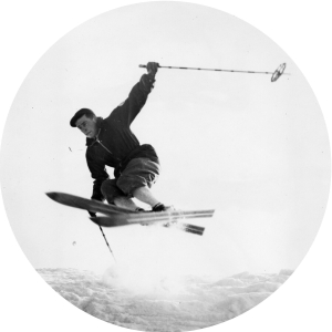 Circular image of a student performing a jump on skis