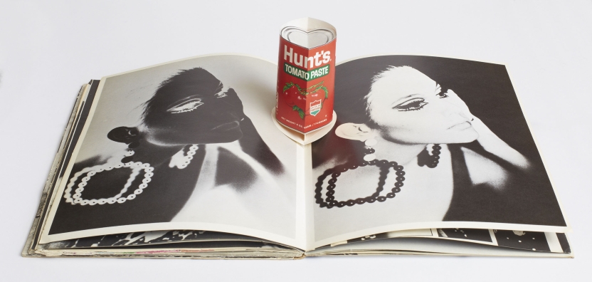 Anthony Warhol pop-up book laid open to a page with photo and negative of a woman. In the center fold, a folded Hunts tomato paste can pops up.