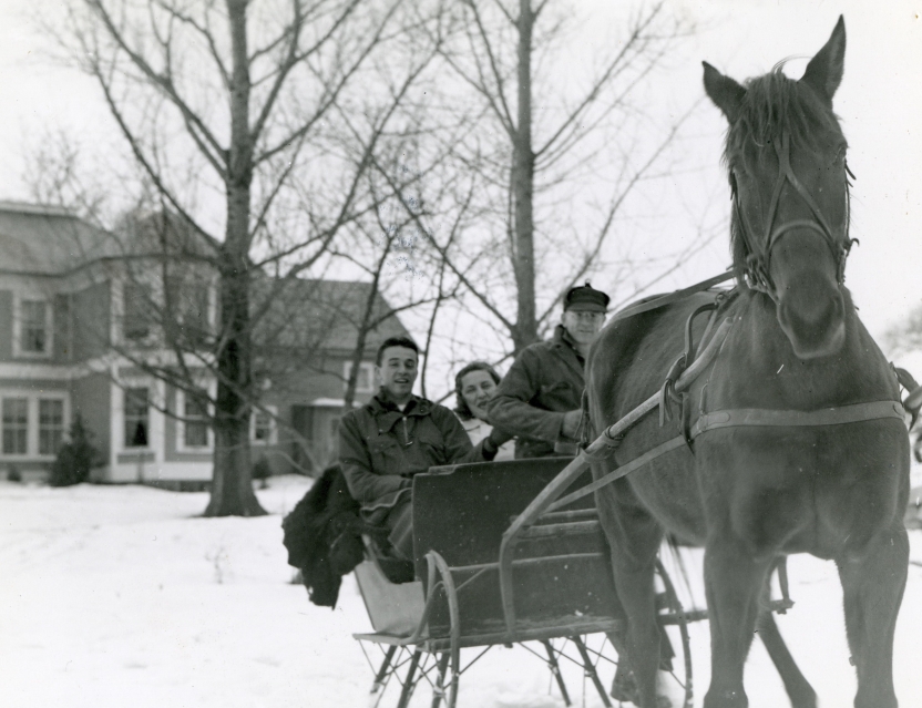 1941 Winter Carnival king and queen riding in horse-drawn carriage through the snow