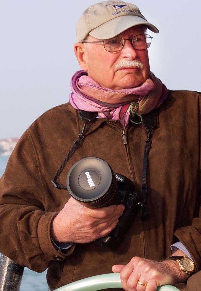 Jim Blair holding a camera and looking debonair