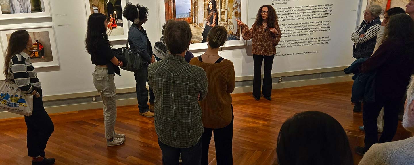a photographer leading a discussion of her photos with a group of people in a museum gallery