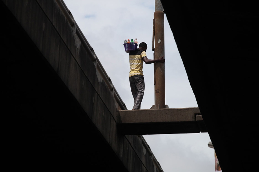 a man carrying a bucket on his shoulder as he works high up in the air