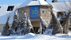 tall conical sculptures woven from saplings and twigs twist and bend together in front of the entrance to the Mahaney Arts Center