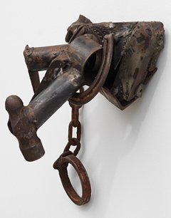 various metal items welded together and displayed on a white wall
