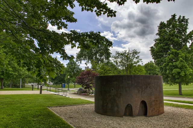 two nested rings of corten steel with cutouts giving the appearance of having been gashed by a large primate