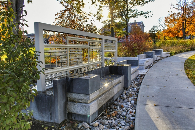 a mostly concrete structure with painted steel, aluminum, and copper elements and plantings