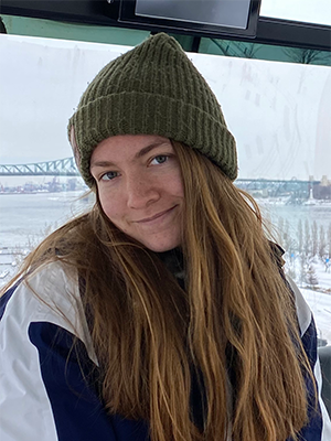 Eliza Broughton '22 dressed warmly for winter with a green knit cap and Middlebury coat