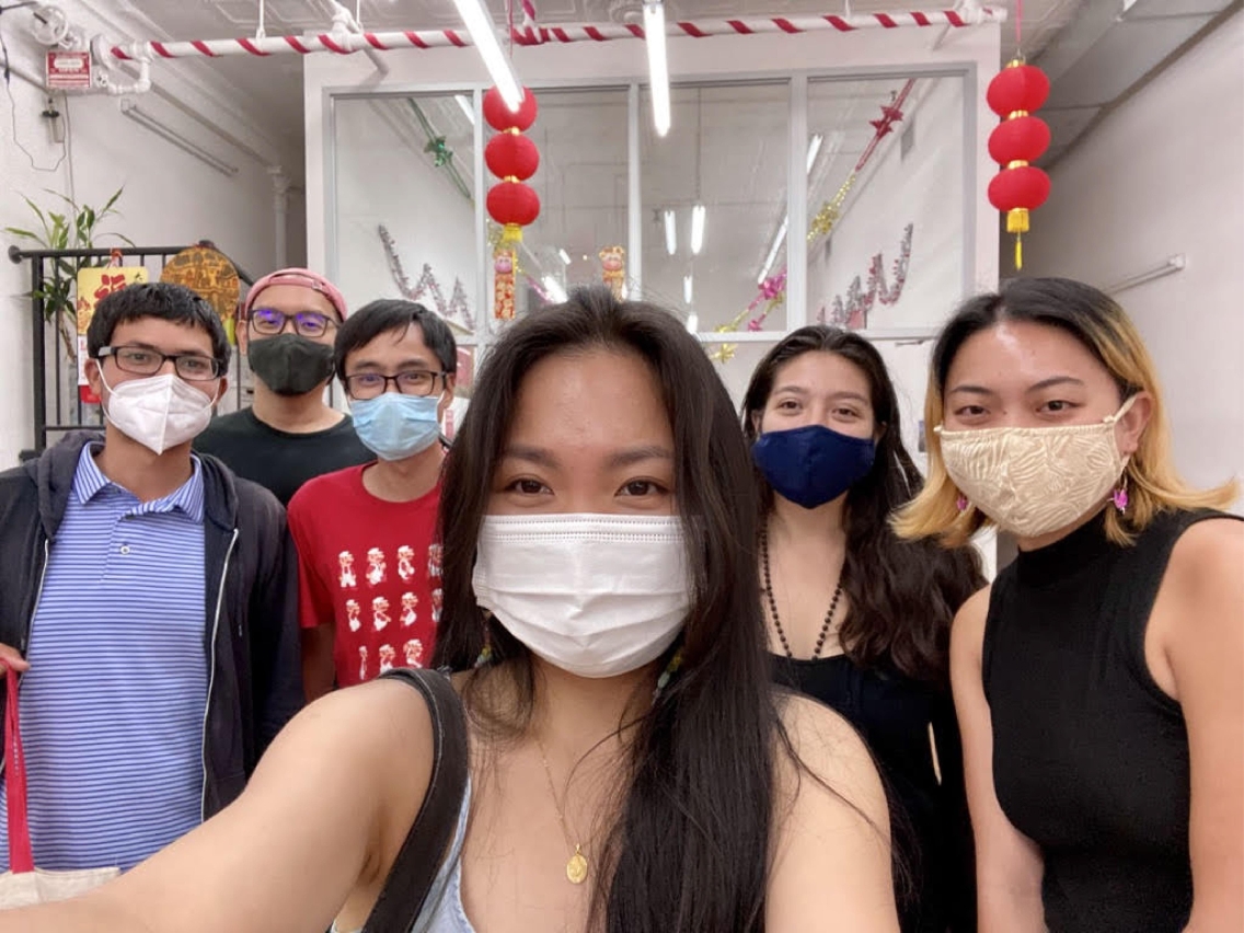Sabrina Lin poses for a selfie in a mask with five other people also wearing masks. 
