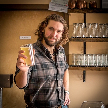 Meadmaker Ricky holding up a glass of his mead.
