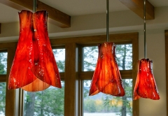 Red floral lighting fixtures hang from the ceiling in a kitchen