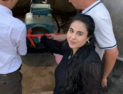 Amina Fatkhulloeva poses for the camera in front of a brand new water pump