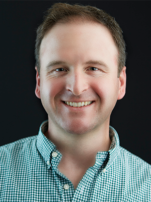 2021 Headshot of Matt Daylor, wearing a light green and white-checked shirt
