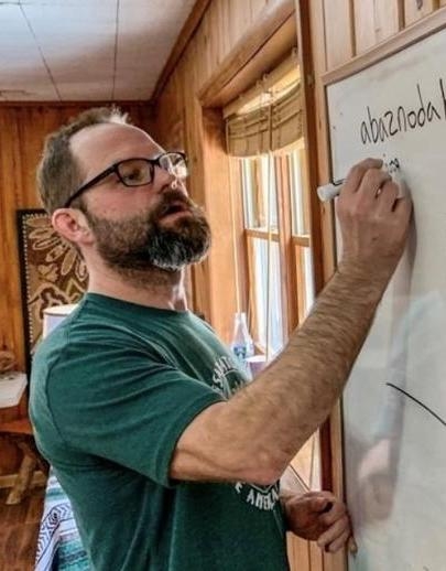 Abenaki School director Jesse Bruchac writes on dry erase board