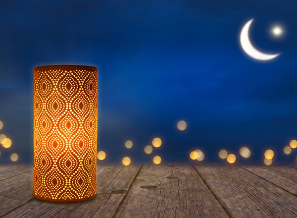 ornate candle, with Islamic crescent moon and star and candle lights in the backgrounde