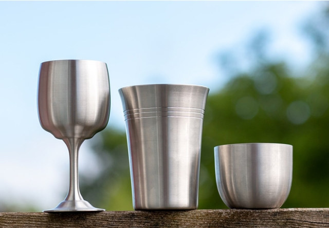 Pewter Cups resting on a wooden table outside