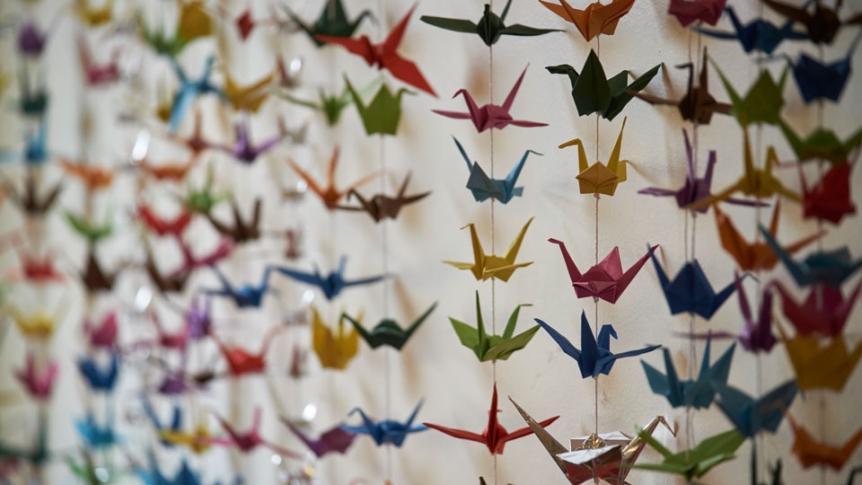 Origami cranes hang in a room.