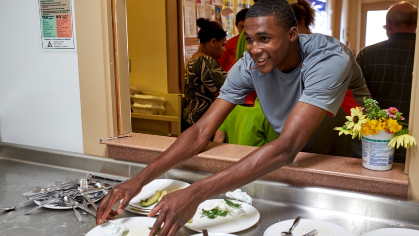 A student helps serve meals at the Congregational Church in Middlebury.