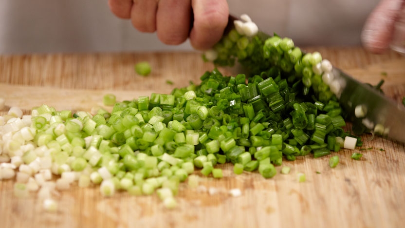 Close up of chopping fresh green vegetables.