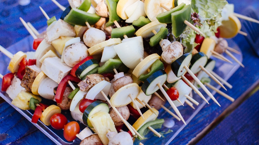 A tray of veggie kabobs prepared to go on the outdoor grill.