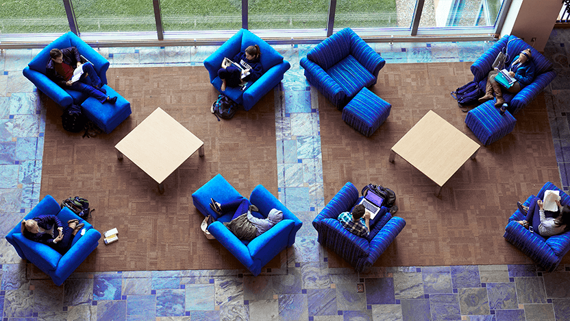 View from above of students studying, reading or napping in cozy blue chairs