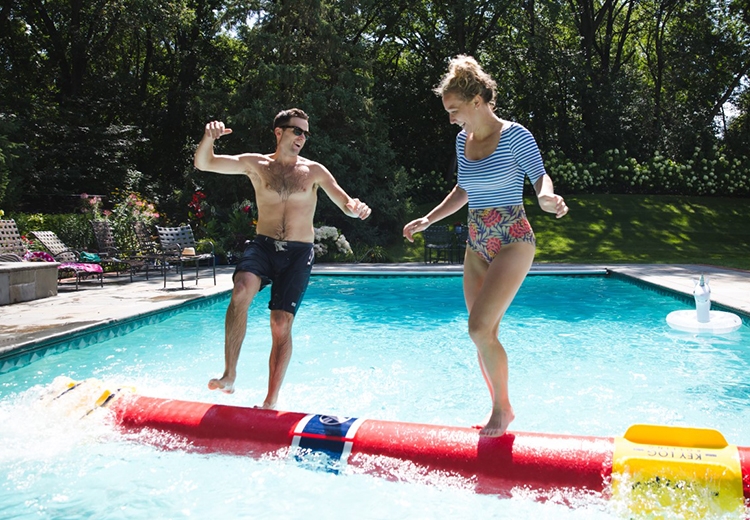 Two people log rolling in a swimming pool