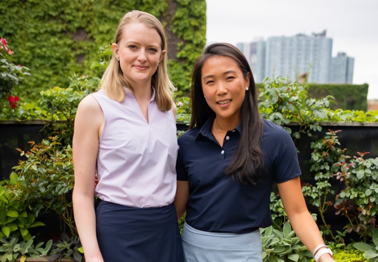 Portrait of two young women wearing golfing apparel looking into the camera