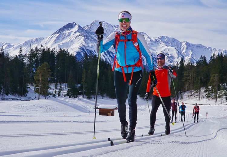 People cross country skiing with mountains in the background