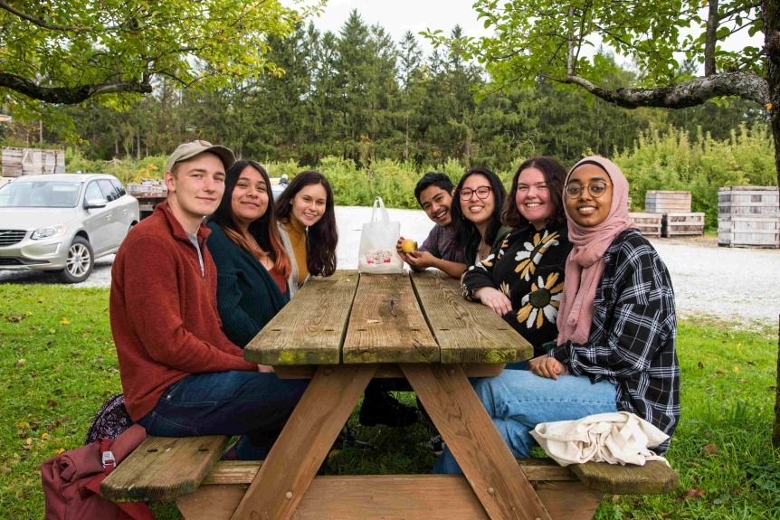Students sitting together at a picnic table.