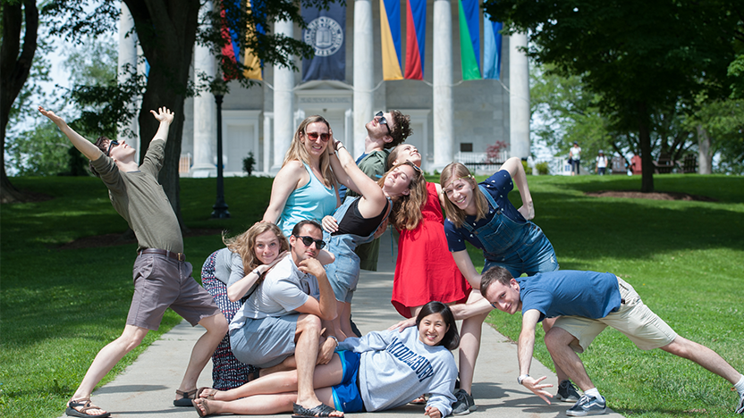 friends from the class of 2013 strike funny poses on the walkway up to the Chapel