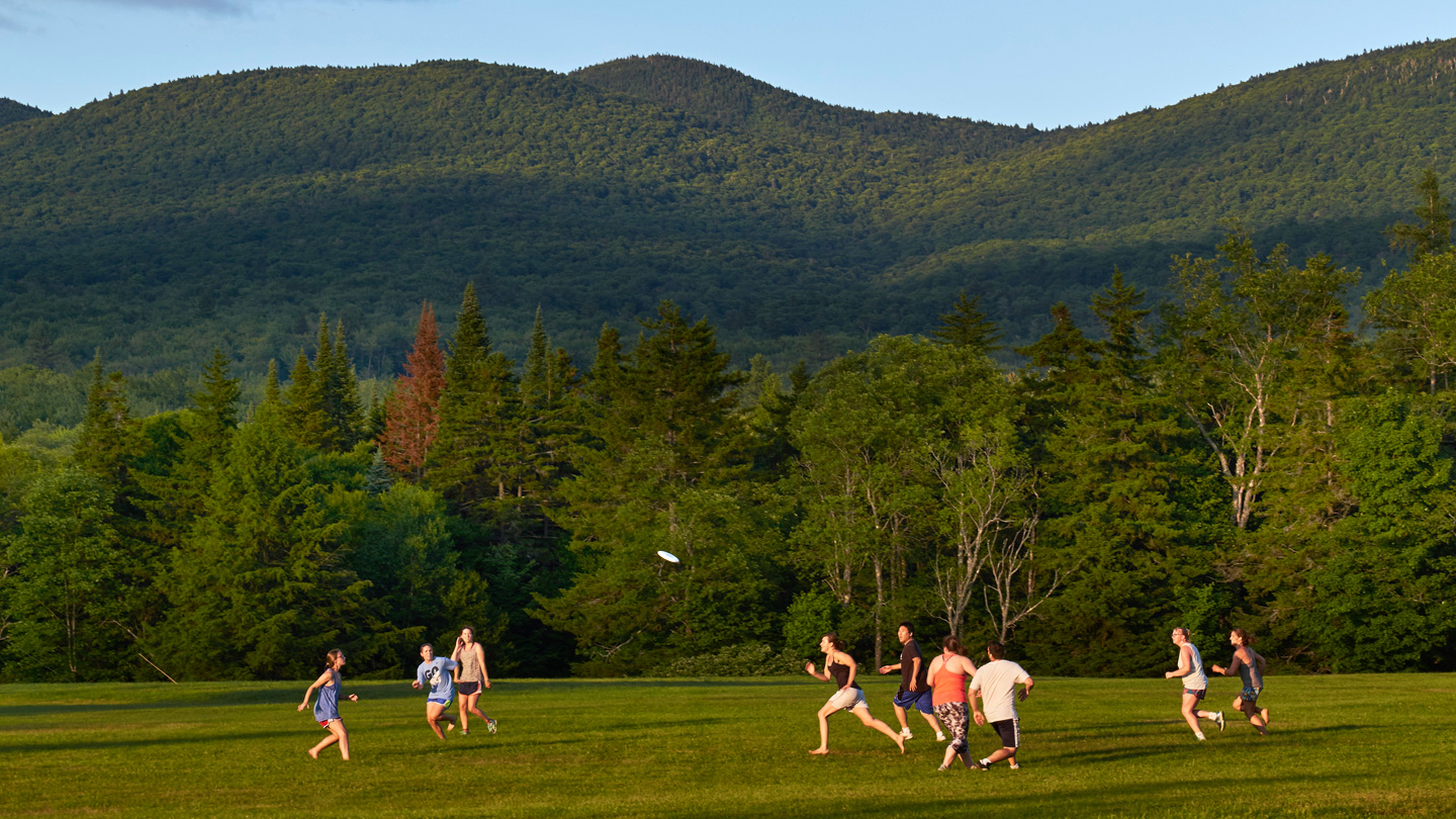 Group of Bread Loaf School of English students playing frisbee outside.
