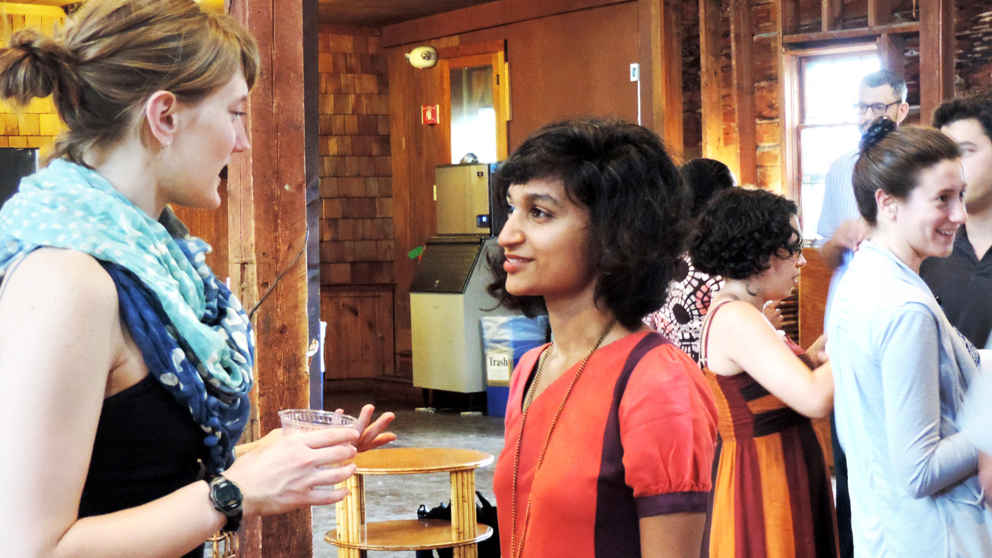Bread Loaf student chats with fellow classmates before an evening lecture in the Barn.