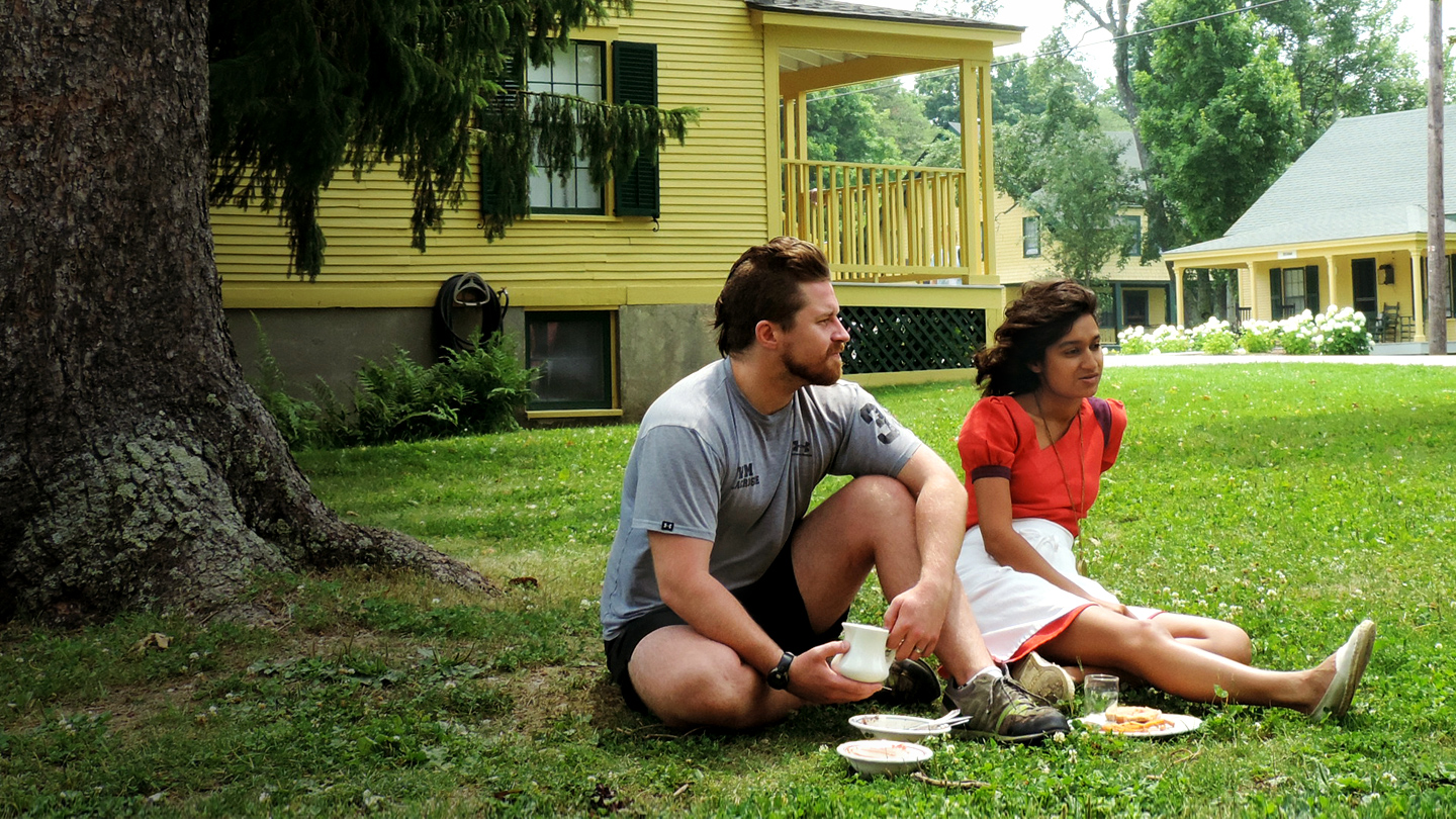 Bread Loaf student and a friend relax on the grass outside the Barn between classes.