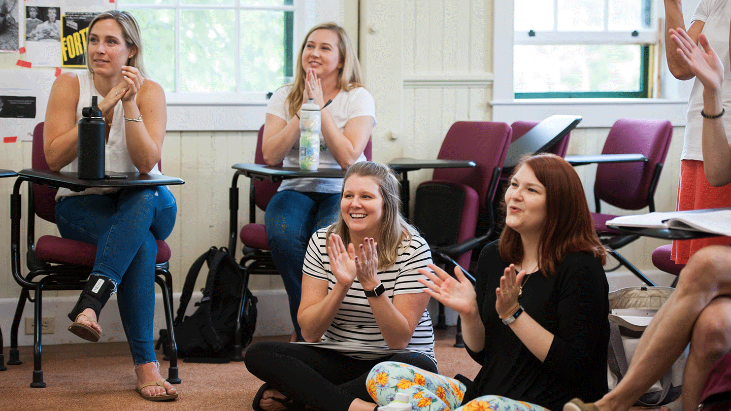 Teachers applaud in a classroom.