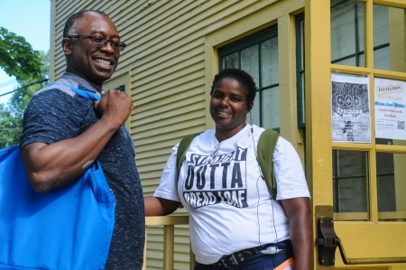 Two Bread Loaf students stand, smiling, outside a campus building in Ripton, Vermont