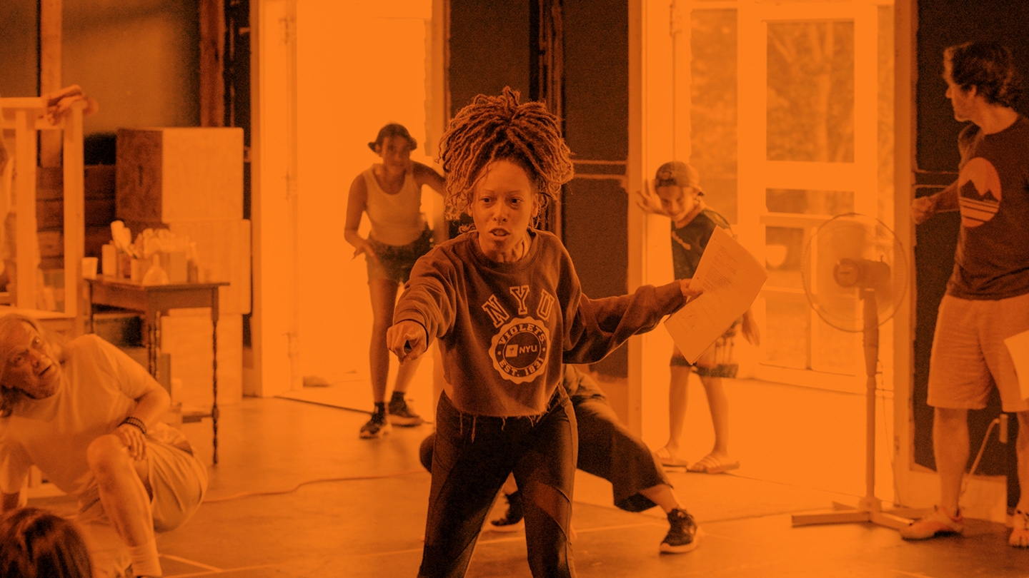 Orange tinted photo of students in a movement class.